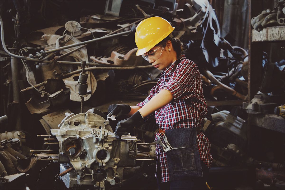 woman working on engine with hardhat